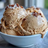 A pint of homemade Hojicha Ice Cream with a rustic wooden scoop, highlighting the nutty caramel notes of roasted green tea.