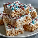Red, white, and blue layered Rice Krispies treats, chewy and vibrant, perfect for festive Independence Day gatherings.