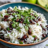 Savory coconut lime rice dish with vibrant black beans, fresh cilantro topping.