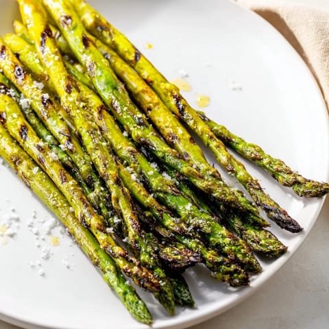 Savory grilled asparagus, lightly charred, ready to serve with lemon for a bright, fresh taste.