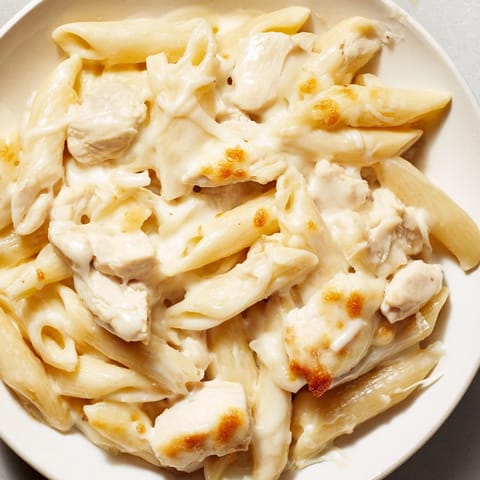 A comforting family meal of baked penne pasta, creamy Alfredo sauce, and tender chicken ready to serve.