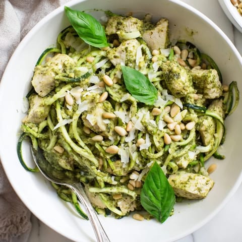 Tender sautéed chicken and crisp zucchini noodles tossed in vibrant basil pesto, topped with toasted pine nuts and Parmesan.
