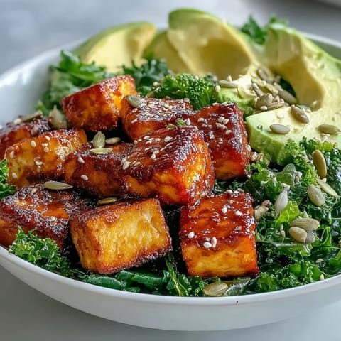 Golden tofu and sautéed kale fill this Tofu Breakfast Bowl, topped with creamy avocado slices and a sprinkle of pumpkin seeds.
