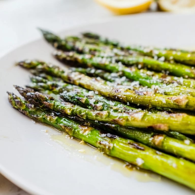 Fresh, tender grilled asparagus, a vibrant side, sprinkled with flaky salt and pepper for dinner.