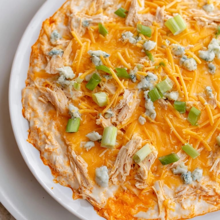 A close-up view of creamy Buffalo Chicken Dip, loaded with melted cheese and shredded chicken.