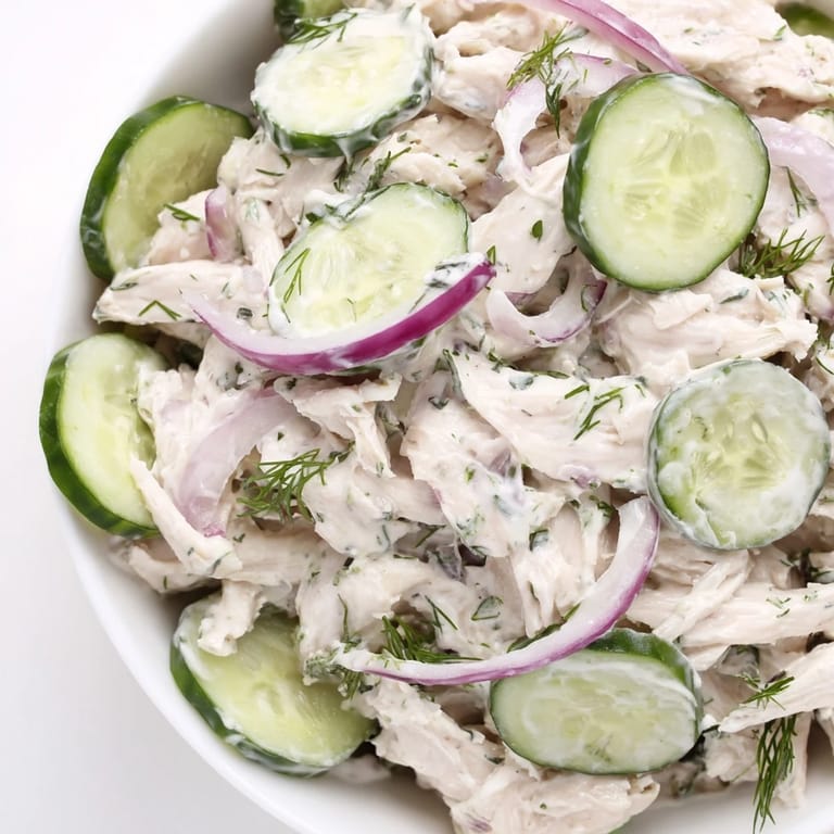Close-up of creamy dill chicken salad with juicy cucumbers, ideal for summer picnics or high-protein meals.