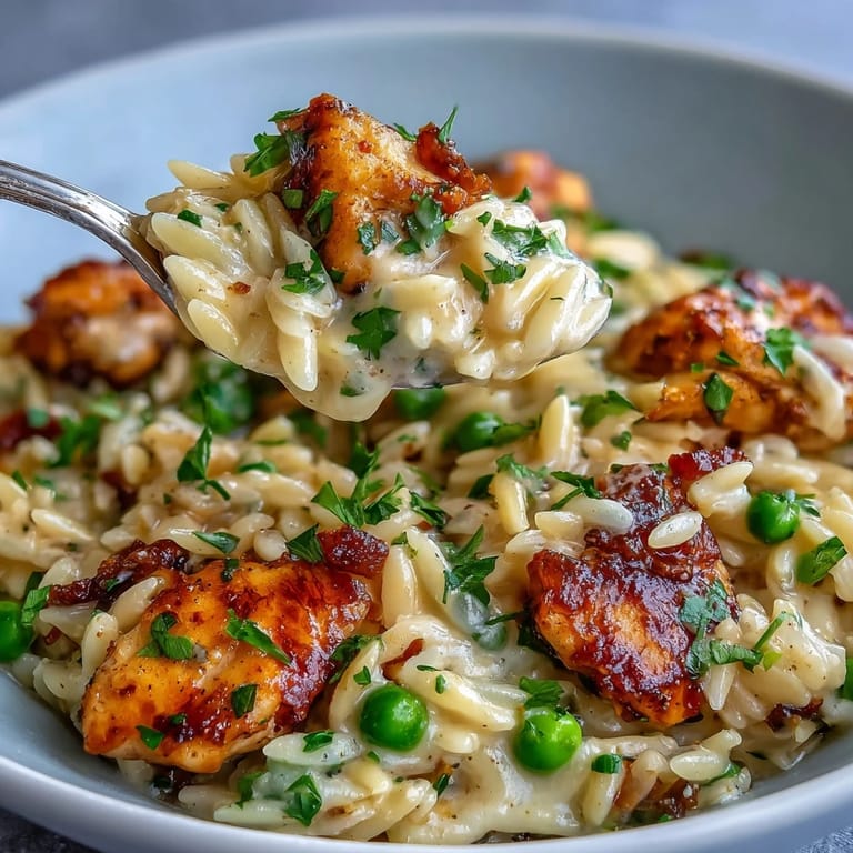 A comforting one-pan dinner of orzo pasta, zesty lemon, chicken, and sweet peas—perfect for busy weeknights.